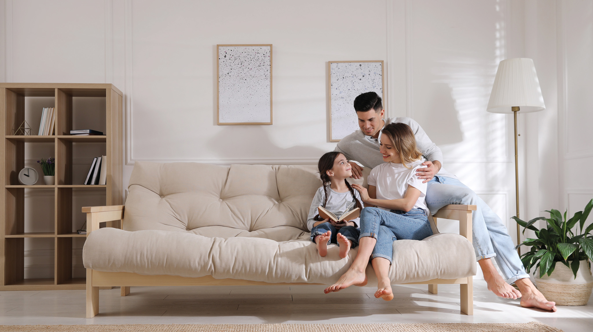Famille assise sur un canapé dans un logement neuf et moderne.